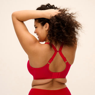 Model wearing Elomi Brianna half cup bra in Haute Red with racerback straps, back view