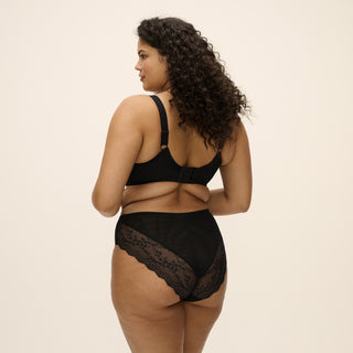 Model wearing Elomi Lucie Jet high leg brief and matching stretch plunge bra in black, back view